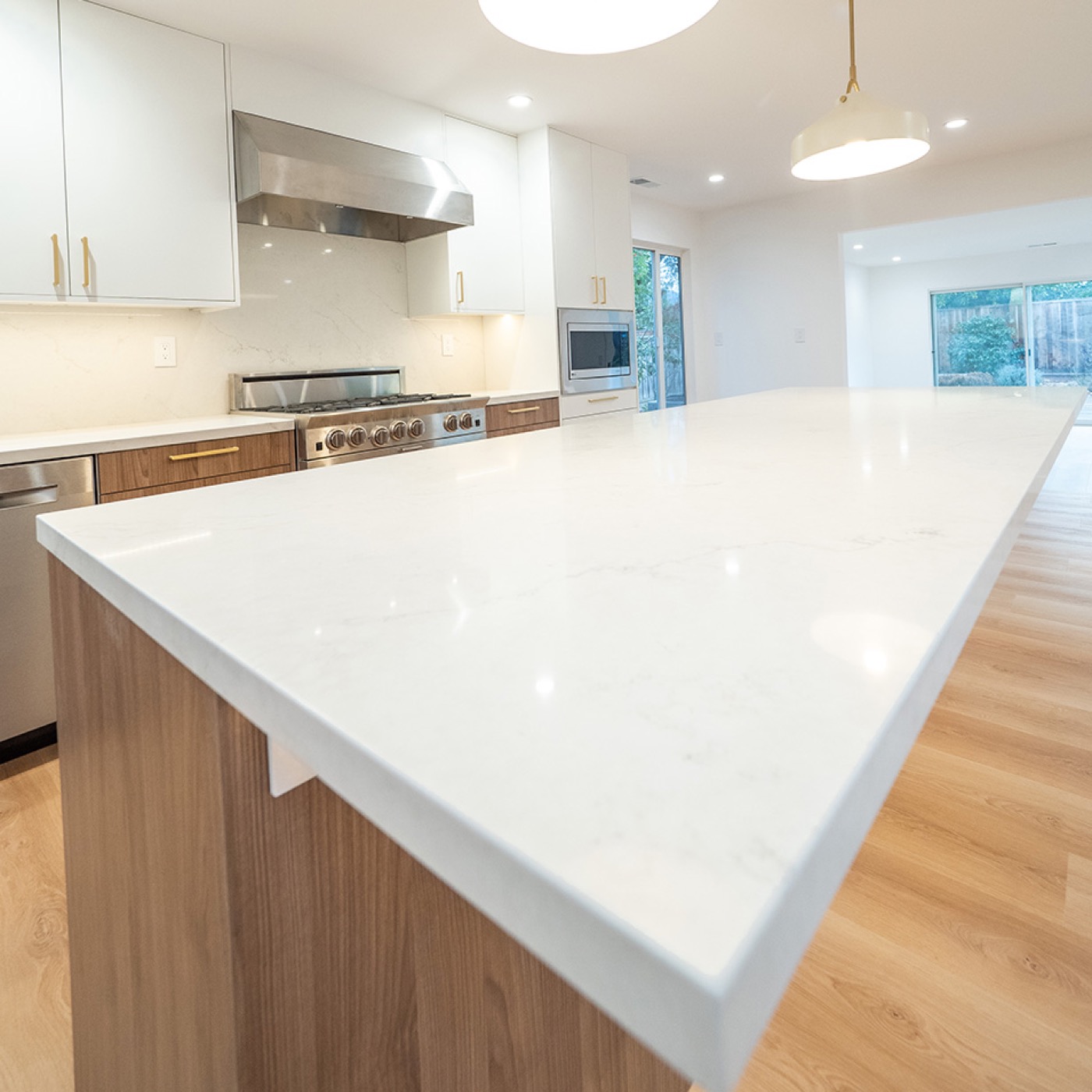 Luxury kitchen remodel with oversized quartz island and brass fixtures in Silicon Valley